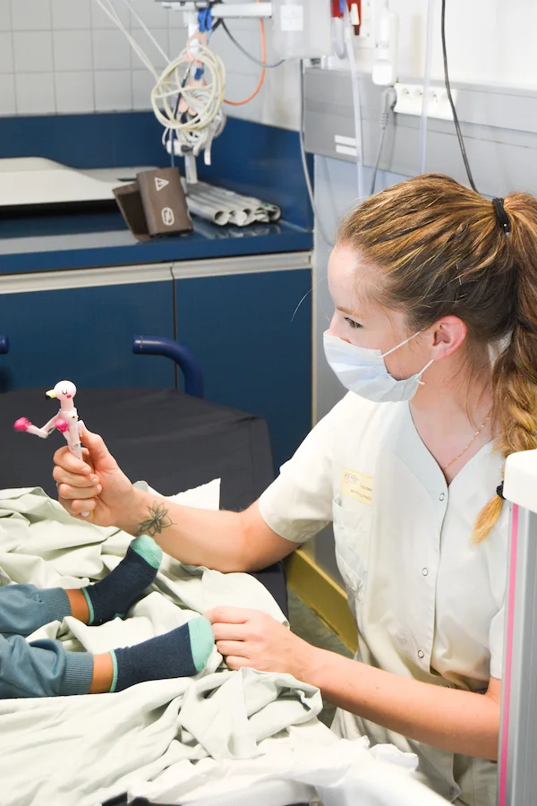 Une soignante souriante, masquée